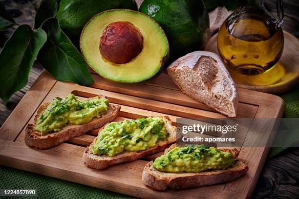 snack oder vorspeise von avocadoscheiben bruschetta mit olivenöl, pfefferminze und salz - aguacates stock-fotos und bilder