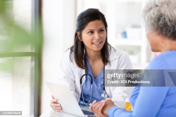 le patient féminin écoute attentivement au docteur féminin adulte moyen - display cabinet photos et images de collection