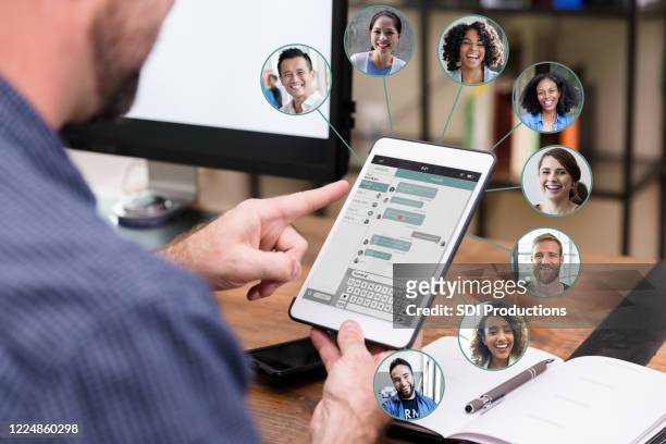unrecognizable man chats online with business associates - employee engagement stock pictures, royalty-free photos & images