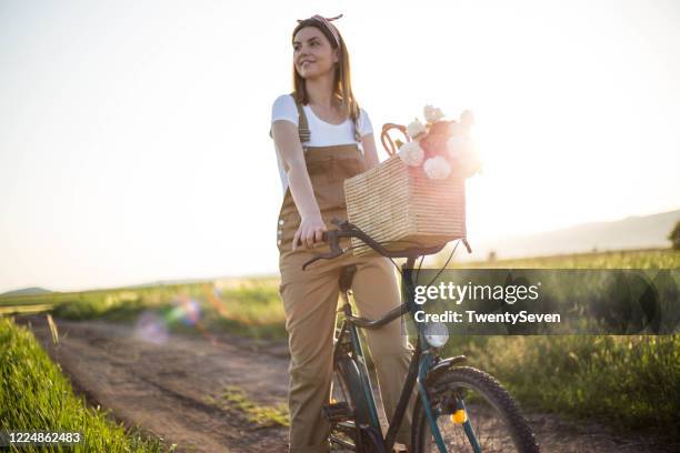 frau mit dem fahrrad in der natur - bike flowers stock-fotos und bilder