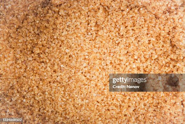 close-up of brown sugar crystals background - zucchero di canna foto e immagini stock