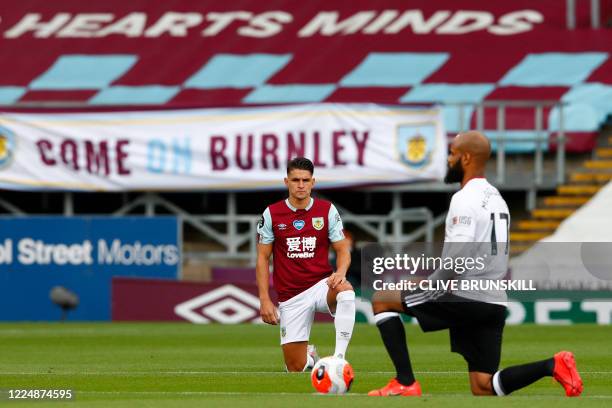 Burnley's English midfielder Ashley Westwood takes a knee to protest against racism and show solidarity with the Black Lives Matter movement before...