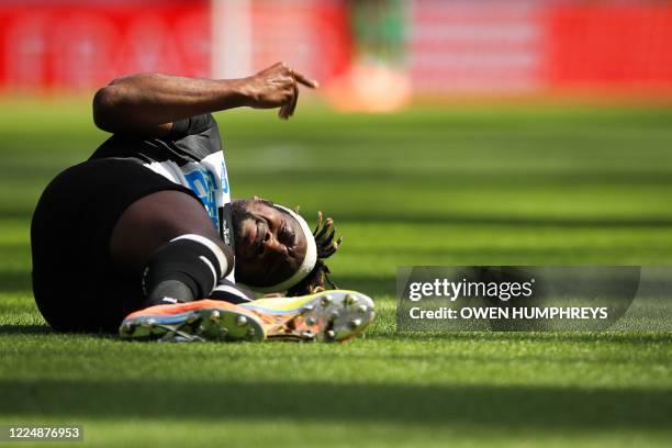 Newcastle United's French midfielder Allan Saint-Maximin reacts on the pitch after an injury during the English Premier League football match between...