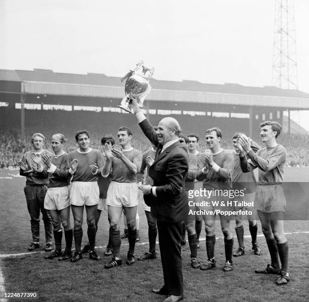 Manchester United manager Matt Busby holding the League Championship trophy after the Football League Division One match between Manchester United...