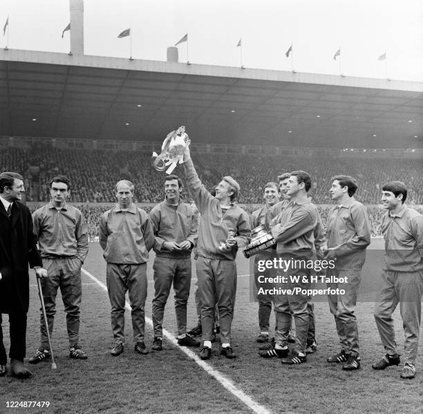 Denis Law of Manchester United lifts the League Championship trophy during the presentation following the Football League Division One match between...