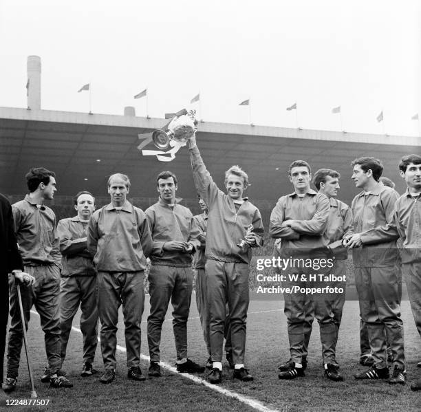 Denis Law of Manchester United lifts the League Championship trophy during the presentation following the Football League Division One match between...