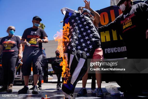 Protesters set fire to an American flag near President Donald Trumps Star on the Hollywood Walk of Fame, part of the Demonstrate How to Dishonor the...