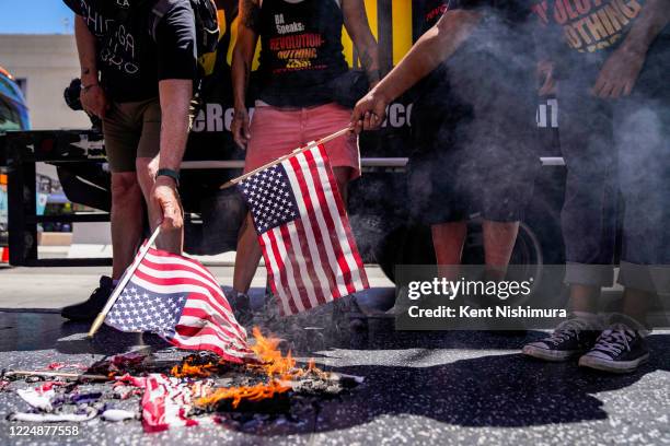 Protesters set fire to an American flag near President Donald Trumps Star on the Hollywood Walk of Fame, part of the Demonstrate How to Dishonor the...