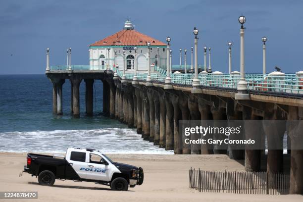Manhattan Beach police patrol near the pier letting people know the beach is closed thru the weekend on Friday, July 3, 2020 in Manhattan Beach, CA....