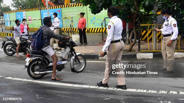 Traffic Police personnel penalize the two wheeler rider for not wearing helmet and also for the pillion rider at Prabhadevi, on July 5, 2020 in...