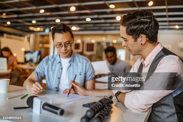 two businessmen analyzing document at office - hearing loss at work stock pictures, royalty-free photos & images