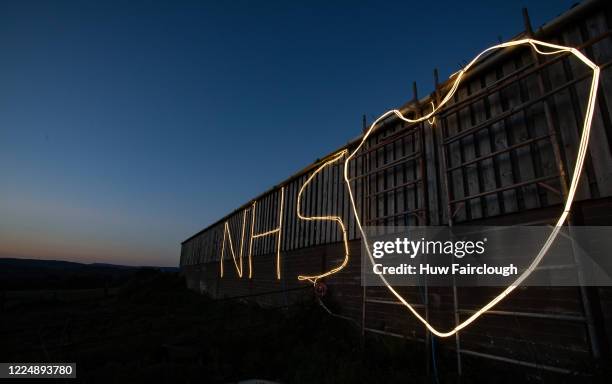 General view of Cefn Caerllwyn Farm, where the owners have illuminated the side of a barn in support of the NHS on May 14, 2020 in Blackwood, Wales,...