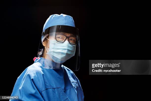 portrait of healthcare worker wearing face shield - portrait on black background stock pictures, royalty-free photos & images