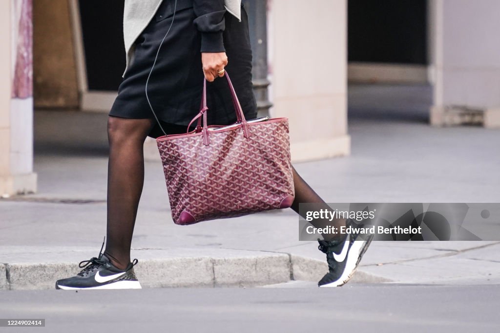 A passerby wears a purple Goyard bag, black Nike sneakers, in the News  Photo - Getty Images