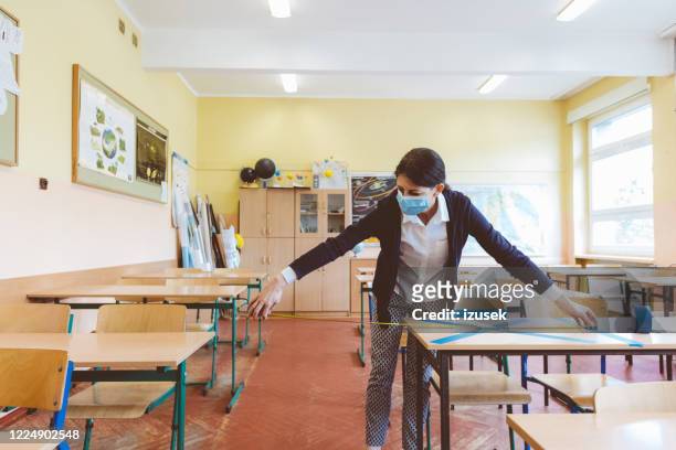 covid-19 the teacher marks empty places in the classroom - epidemic school stock pictures, royalty-free photos & images