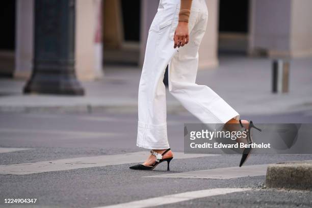 Passerby wears white jeans, bejeweled pointy shoes, in the streets of Paris, on May 14, 2020 in Paris, France.