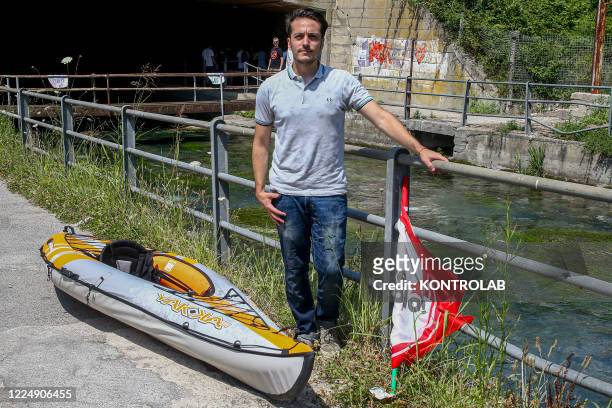 Giuliano Granato, candidate to the Regional Elections for Potere Al Popolo Party poses next to a canoe on a river.