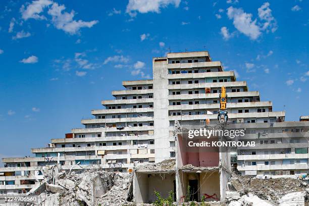 Backhoe excavator is finishing of the demolishing of the Green Sail building "Vela Verde" in Scampia, in the suburb of Naples. The northern...