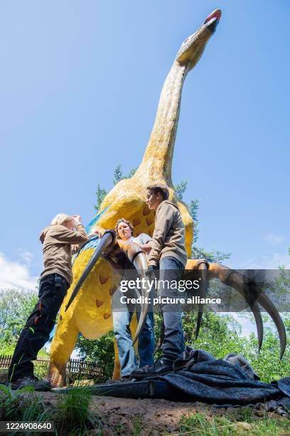 July 2020, Lower Saxony, Rehburg-Loccum: Employees Alessandro Stauf , Jens Kosch and Yannik Weber are mounting a large claw on a new model of a...