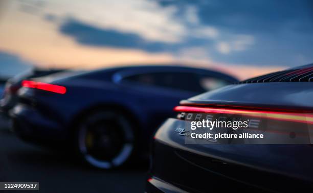 June 2020, Saxony, Leipzig: A Porsche 911 Carrera 4S stands in the evening light in a drive-in cinema on the circuit of the Leipzig Porsche factory....