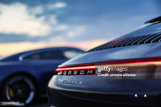 June 2020, Saxony, Leipzig: A Porsche 911 Carrera 4S stands in the evening light in a drive-in cinema on the circuit of the Leipzig Porsche factory....