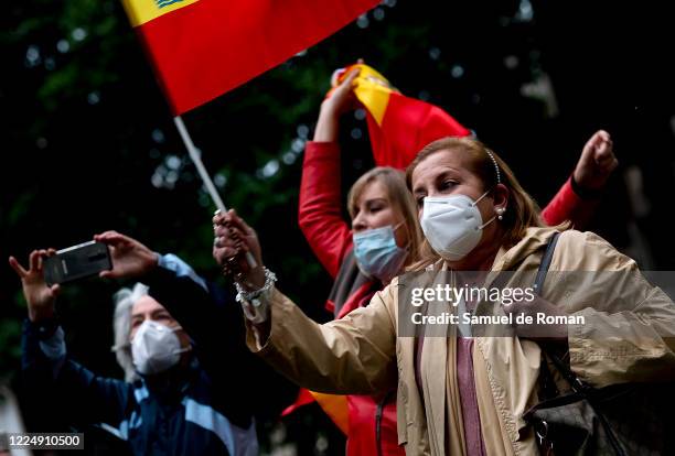 Woman waves a flag of Spain during protest by residents of the neighborhood of Salamanca on Calle Nuñez de Balboa against the government's management...
