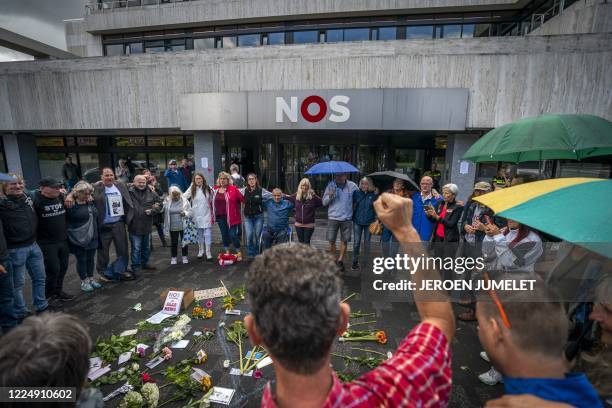 Protesters gather around flowers outside the Dutch public broadcaster NOS building in Hilversum on July 6 during a demonstration to protest what they...