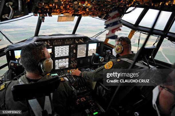 Pilots of the Mexican Air Force are seen in the cabin of a Hercules C-130 plane as they transport medical supplies in Hermosillo City, Sonora state,...