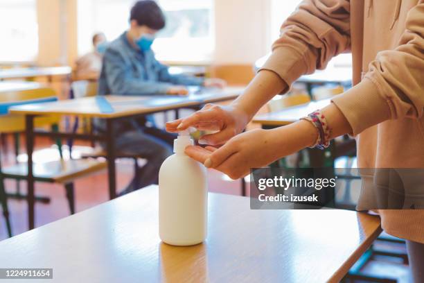 handontsmettingsmiddel gebruiken in de klas - social distancing classroom stockfoto's en -beelden