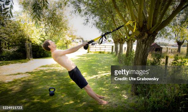 In this photo illustration a man is using a TRX Band for outdoor sports on June 25, 2020 in Oostkapelle, Netherlands.