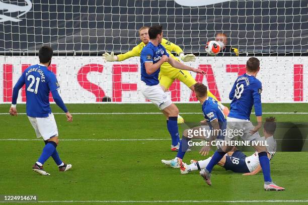 Tottenham Hotspur's Argentinian midfielder Giovani Lo Celso scores the opening goal from a deflection off of Everton's English defender Michael Keane...