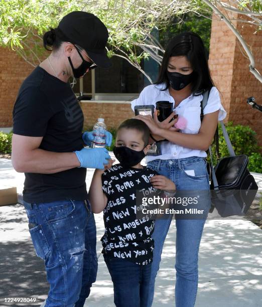 Illusionist Criss Angel, his son Johnny Crisstopher Sarantakos and Shaunyl Benson visit as Angel helps to give out food and other items at the Cure 4...
