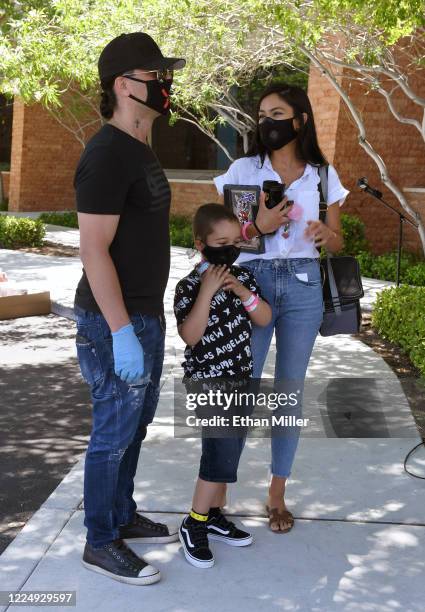 Illusionist Criss Angel, his son Johnny Crisstopher Sarantakos and Shaunyl Benson visit as Angel helps to give out food and other items at the Cure 4...