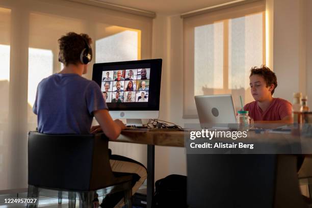 two teenage brothers studying from home on computers - secondary school covid stock pictures, royalty-free photos & images