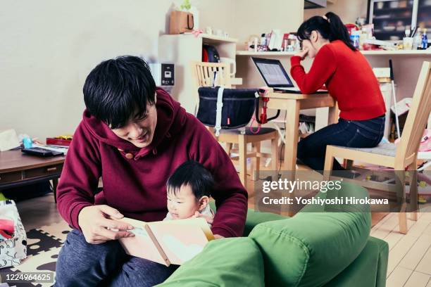 father takes care of daughter and mother is busy working from home - 40's rumpled business man stockfoto's en -beelden