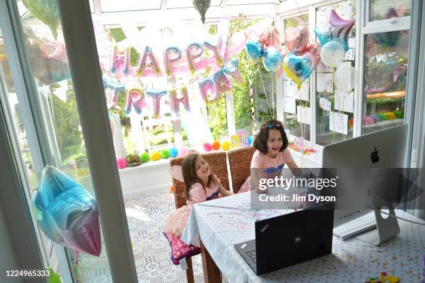 Twin sisters, daughters of the photographer, enjoy a Zoom party for their fourth birthday, on May 14, 2020 in Buckinghamshire, United Kingdom. The...