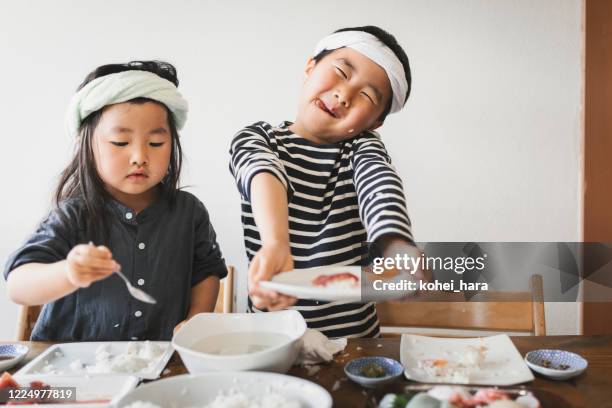 siblings cooking sushi at home - making sushi stock pictures, royalty-free photos & images