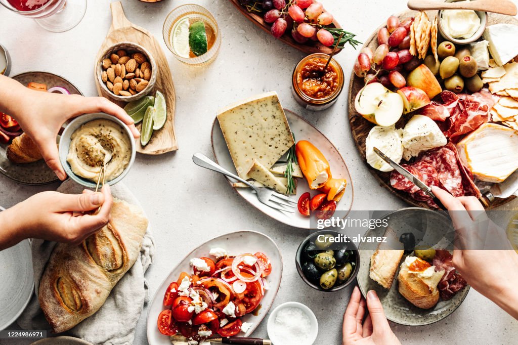 Women eating fresh Mediterranean platter on table
