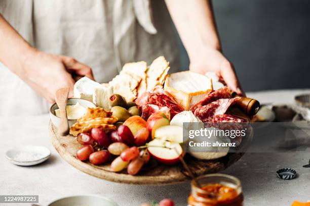 mittelteil der frau serviert meze-platte auf dem tisch - tray stock-fotos und bilder