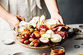 Midsection of woman serving meze platter on table