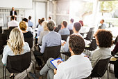 Back view of large group of entrepreneurs on a seminar.