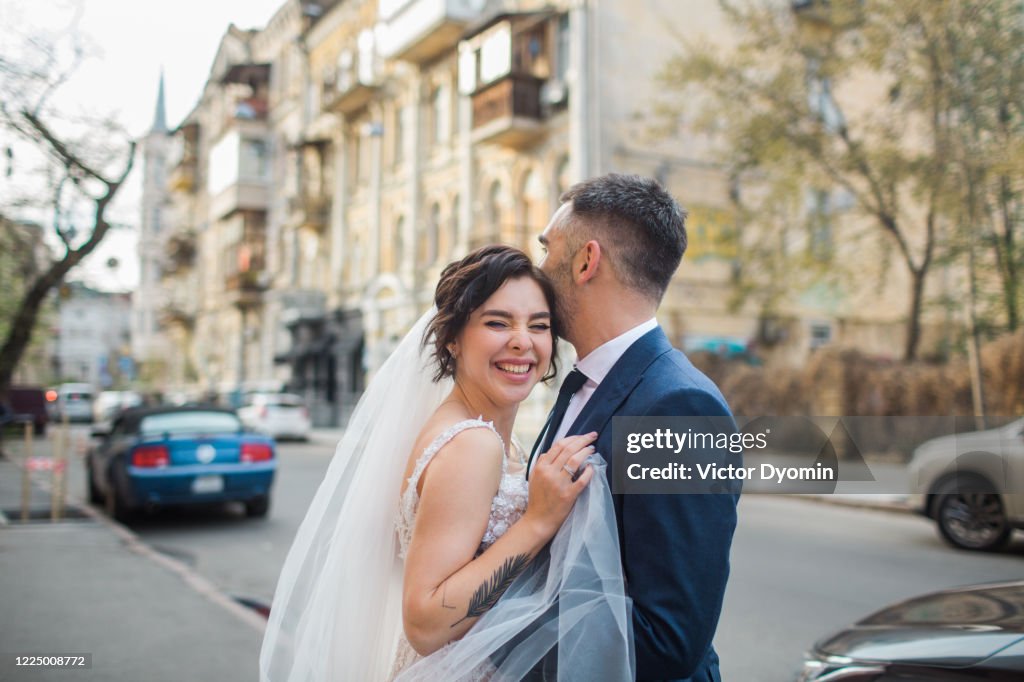 Wedding portrait of a young couple on a city street