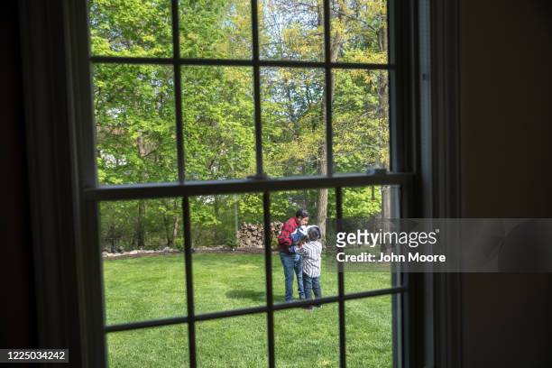 Marvin passes his infant son Neysel, six weeks, to Junior on May 14, 2020 in Stamford, Connecticut. Marvin and his family Zully and Junior, now all...