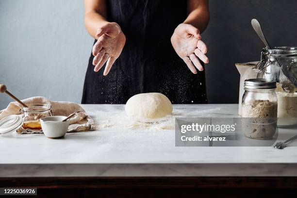 woman throwing dough on flour over marble counter - hand pastry stock pictures, royalty-free photos & images