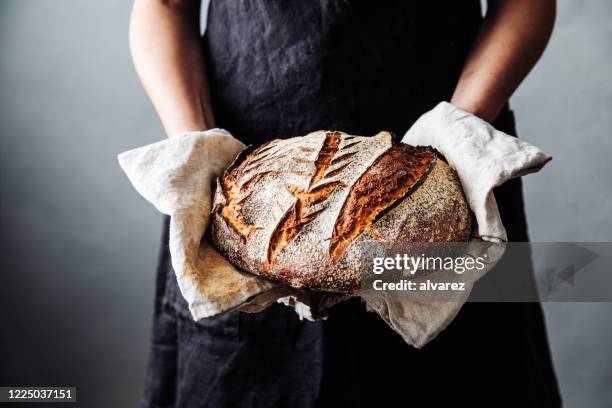 mujer con pan de masa fermentada recién horneada en la cocina - al horno fotografías e imágenes de stock