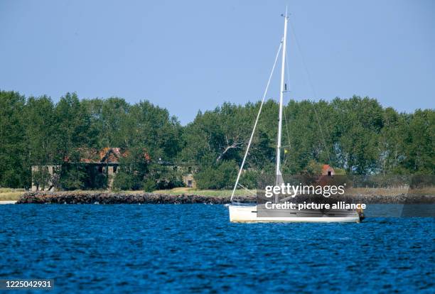 July 2020, Mecklenburg-Western Pomerania, Ruden: A sailing boat passes the Baltic Sea island of Ruden in the Greifswald Bodden. The island at the...