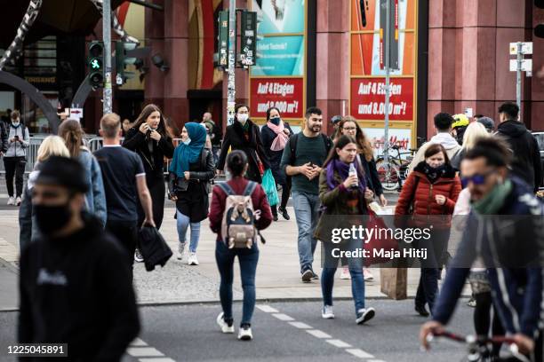 People cross the street near shopping mall on May 14 in Berlin, Germany. As authorities continue to ease lockdown restrictions nationwide businesses...