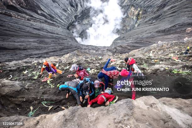 Tengger tribe people make their way to the summit of Mount Bromo volcano to make offerings in Probolinggo, East Java province on July 7 as part of...