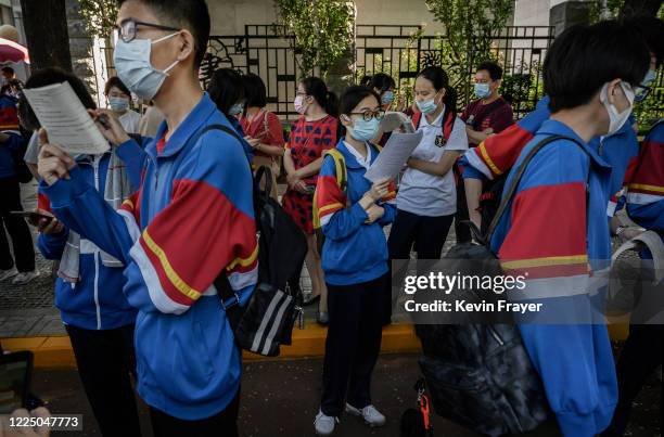 Chinese students do last minute studies outside a school before entering to take the National College Entrance Examination, also known as Gaokao, at...