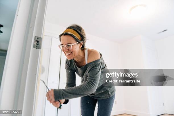 woman painting a bedroom - white paint roller stock pictures, royalty-free photos & images